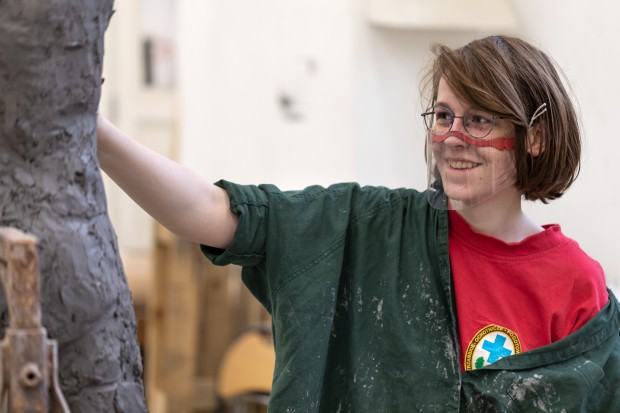 _m6a0370.jpg Uśmiechnięta dziewczyna rzeźbi w glinie