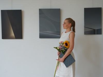 Katarzyna Sikorska na tle obrazów z cyklu „Blaski i cienie"